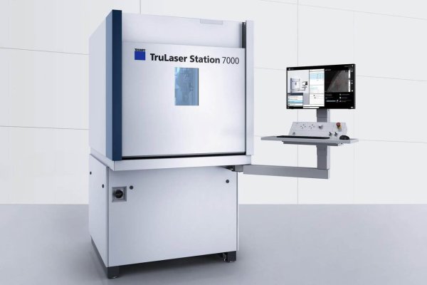 Die TruLaser Station 7000 steht in einem modernen Raum mit Steuerpult, zwei Monitoren und Sichtfenster für Blechbearbeitung.