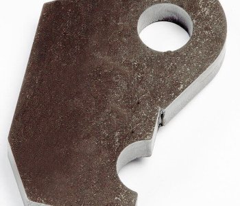Eine flache, unregelmäßig geformte Blechplatte mit grossem Rundloch und kleiner Ausklinkung auf weissem Hintergrund.