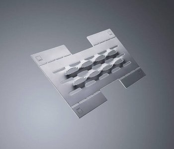 Ein flaches Blech mit rechteckiger Form, ovalen Prägungen in der Mitte und Ausstanzungen am Rand auf grauem Hintergrund.