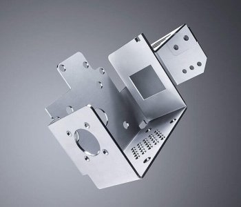 Präzise geschnittenes Blechbauteil mit Löchern und Abkantungen schwebt vor grauem Hintergrund, ideal für industrielle Montage.