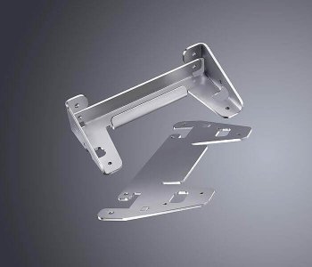 Ein Metallwinkel und zwei gelochte Blechplatten mit Ausstanzungen liegen auf grauem Verlauf, geeignet für mechanische Montage.