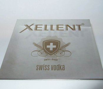 Silbernes Metallschild mit Xellent-Logo, Schild mit weissem Kreuz, Swiss Made und der Aufschrift Swiss Vodka unten.