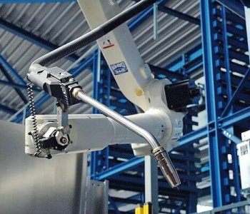 Detailaufnahme eines Industrieroboters mit Schweissbrenner in moderner Blechbearbeitungsfabrik mit blauen Stahlträgern.